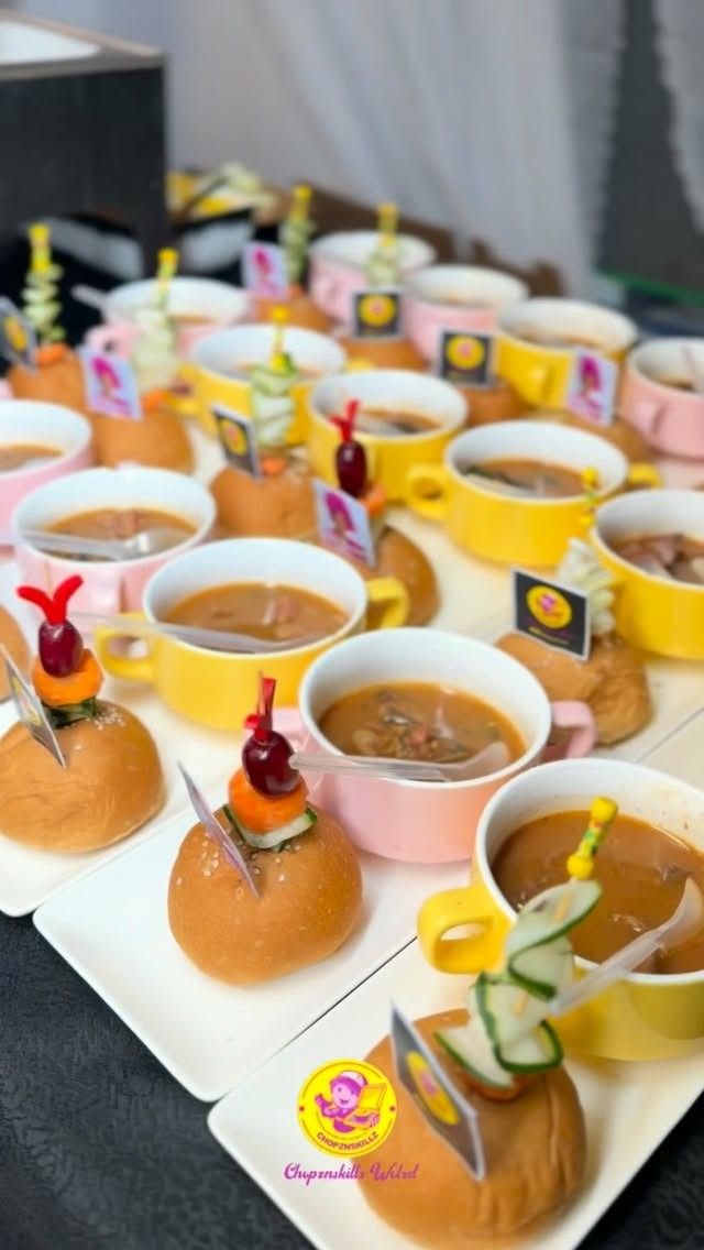 Pepper soup in pink and yellow cups with buns
